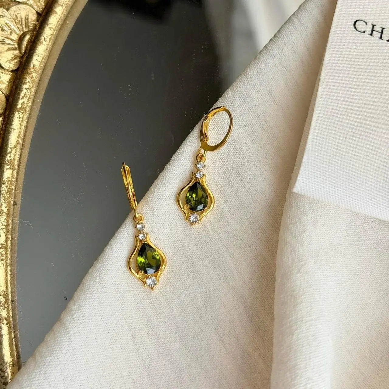 Olive Green Crystal Huggie Drop Earrings Gold Tone — pair shown together on flat lay