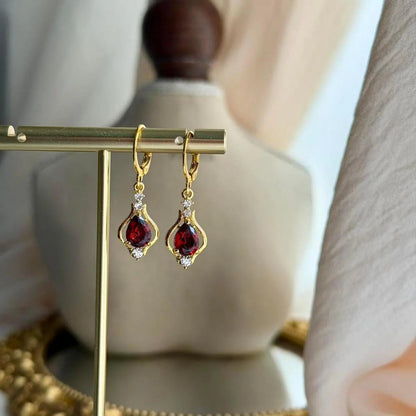 Ruby Red Crystal Huggie Drop Earrings Gold Tone on neutral background — front view