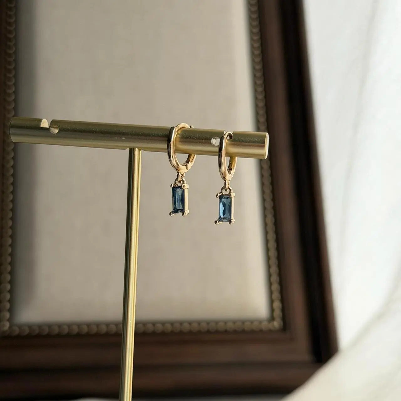 Baguette Blue Crystal Huggie Hoop Earrings 14K Gold — worn on model, side profile