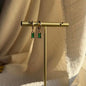 Emerald Baguette Crystal Huggie Hoop Earrings 14K on neutral background — front view
