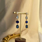 Sapphire Blue Four-Stone Drop Earrings Gold Tone on neutral background — front view