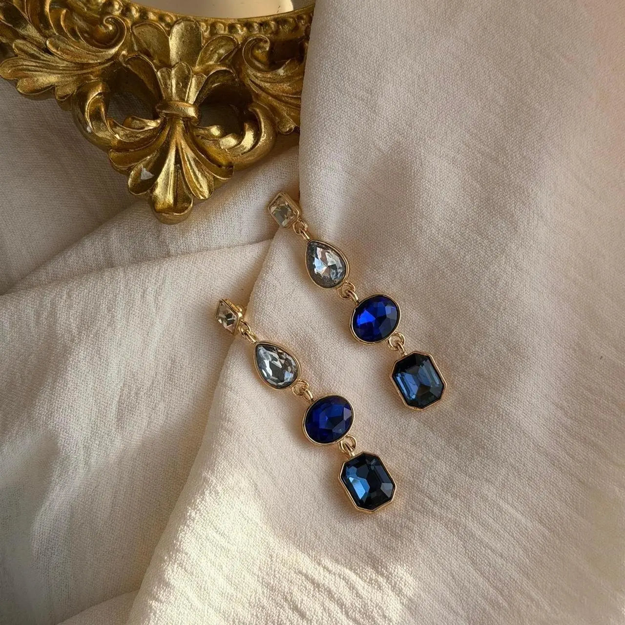 Sapphire Blue Four-Stone Drop Earrings Gold Tone — worn on model, side profile