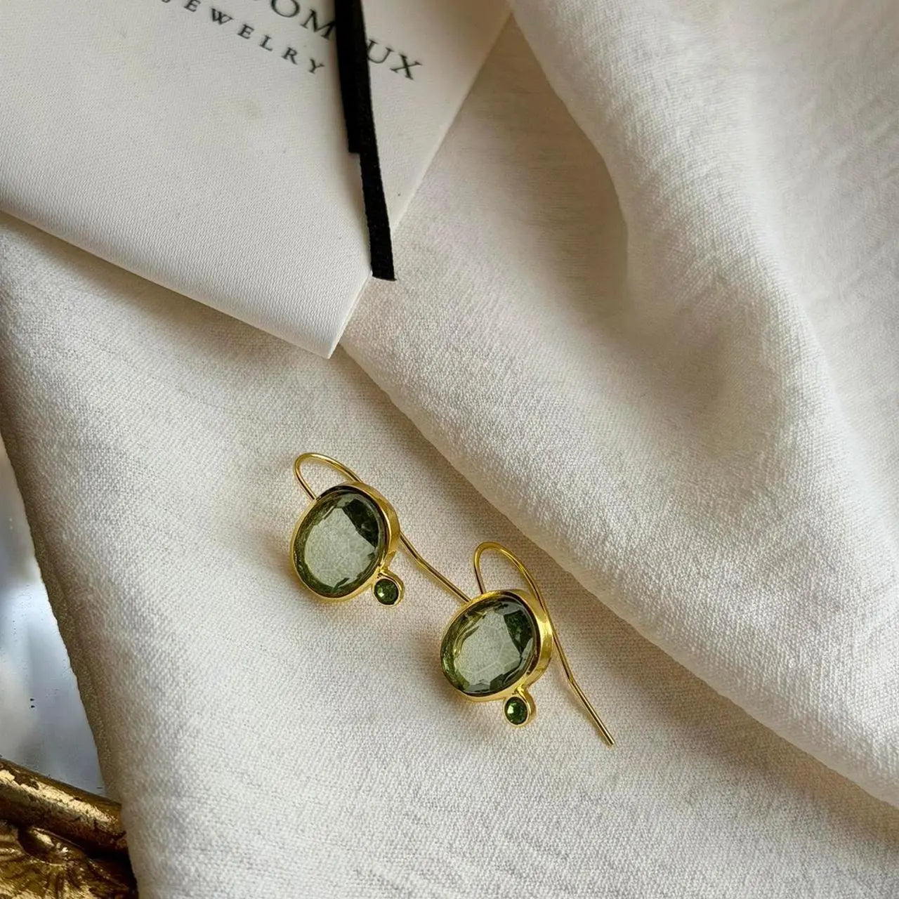 Grey Crystal & Green Accent Drop Earrings Gold — angle highlighting drop and movement