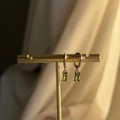 Olive Green Baguette Crystal Huggie Earrings 14K on neutral background — front view