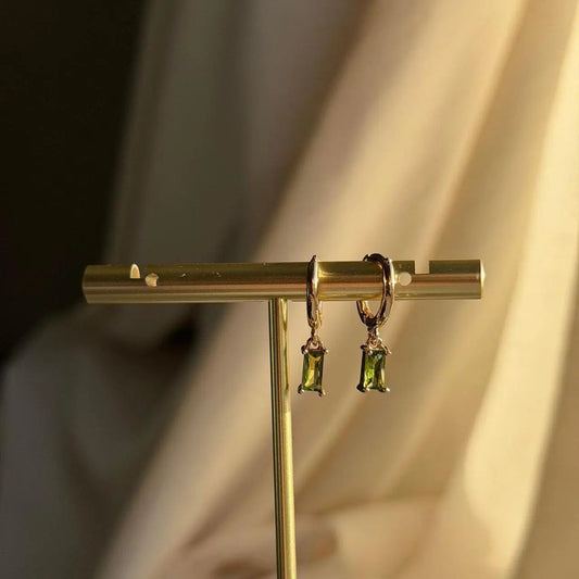 Olive Green Baguette Crystal Huggie Earrings 14K on neutral background — front view