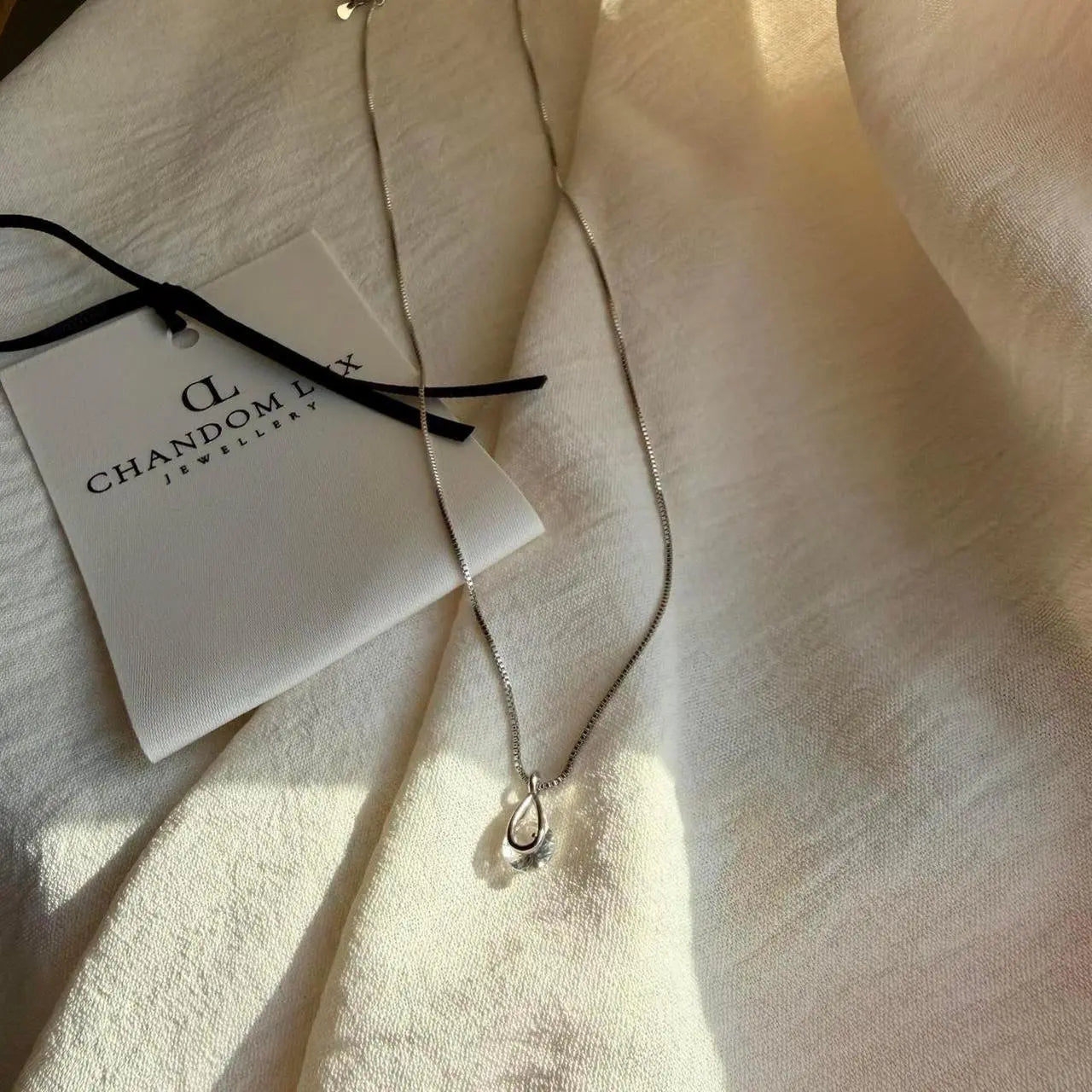 Clear Crystal Teardrop Pendant Necklace S925 Silver — styled flat lay with textures