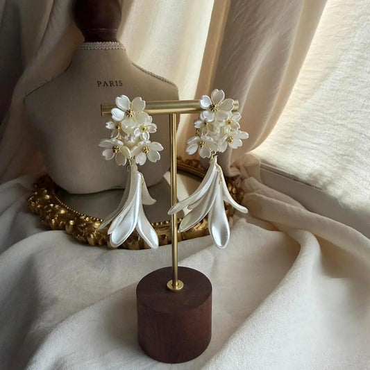 Layered White Floral Drop Earrings Gold Tone Women on neutral background — front view